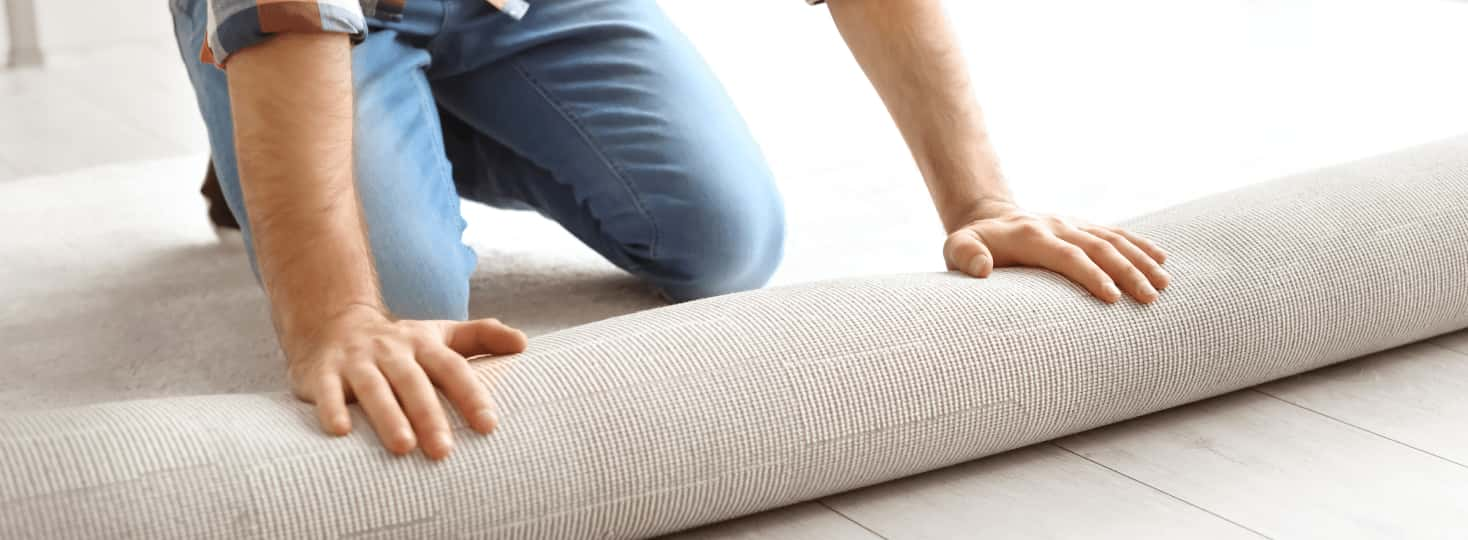 flooring installer laying out carpet roll